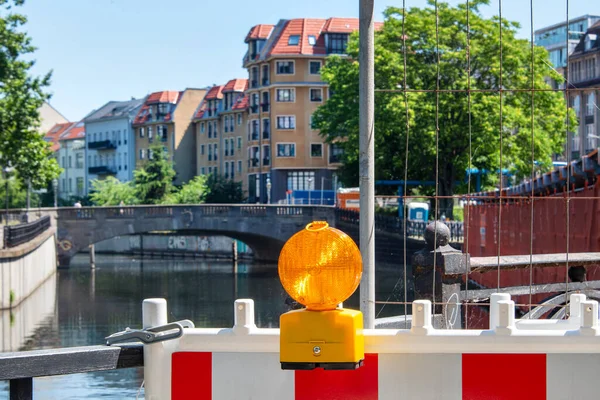 Red and white street barriers with flashlight to secure a construction site, roadworks, road under construction. Temporary fencing, repair on the city street, closed for renovation. No way, stop and detour sign