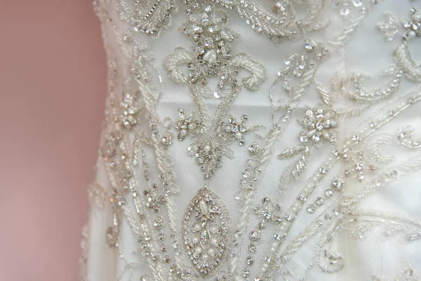 Beautiful bridal dress on hangers. Embroidery with beads. Wedding dress close up at the wedding salon. Wedding dresses hanging on a hanger.