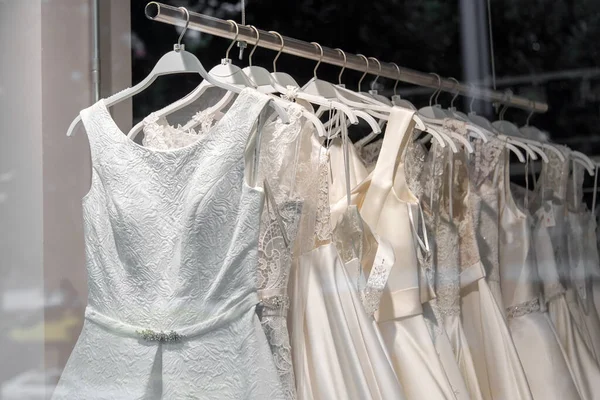 衣架上漂亮的新娘礼服 婚纱紧贴在婚纱沙龙 挂在衣架上的婚纱 新婚夫妇沙龙的内部 — 图库照片