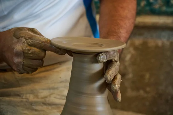 Clay plate. Pottery workshop hands work with clay. A man makes a vase of liquid clay with his hands. Ceramic vase and cup manufacturing process. Do it yourself master class. Place for your text.