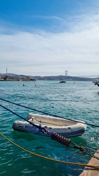 Barco no mar perto do cais. Fatih Sultan Mehmet Bridge através do Bósforo na Turquia — Fotografia de Stock