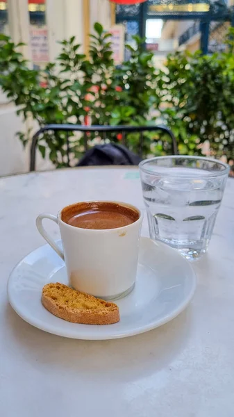 Isolierter türkischer Kaffee in einer weißen Tasse mit einem Fläschchen Wasser und türkischem Dessert — Stockfoto