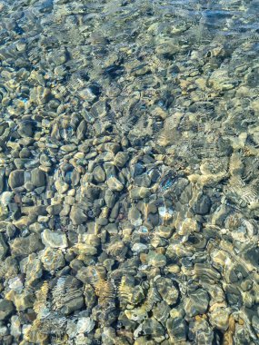 Su altında dalgalı deniz taşları.