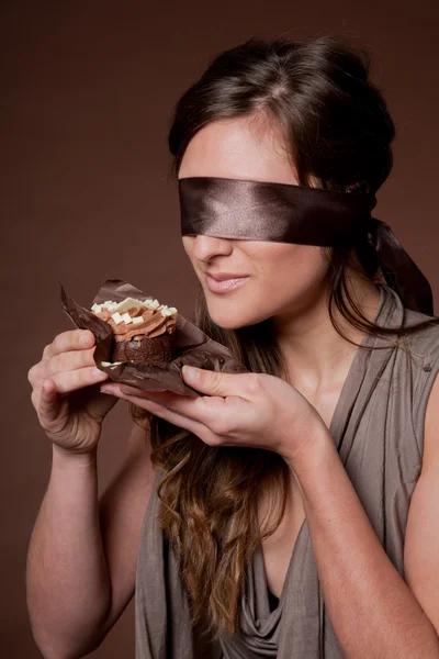 Женщина с завязанными глазами держит торт — стоковое фото