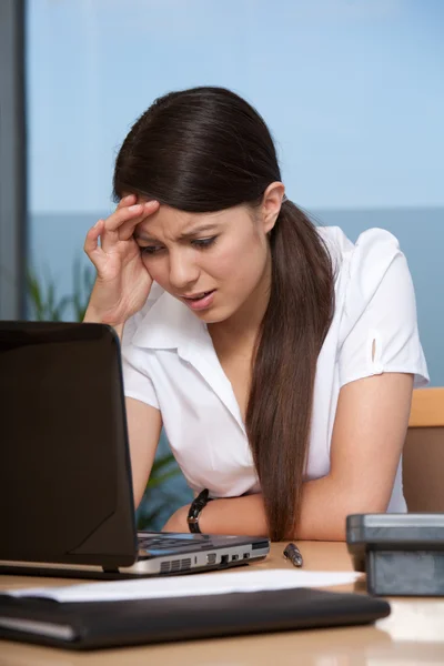Frustrated young woman using laptop Stock Photo