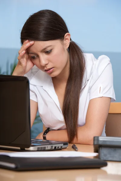 Mujer joven concentrándose mirando el ordenador portátil Imágenes de stock libres de derechos