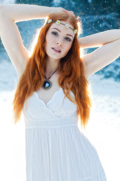 Snow Maiden. Whimsical image of beautiful red head woman standing in snow