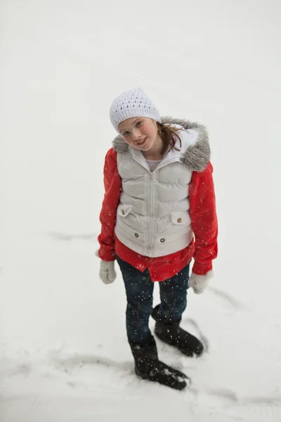 Invierno - jovencita parada afuera mientras cae nieve Imágenes de stock libres de derechos
