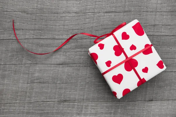 Caixa de presente embrulhada em papel estampado no coração — Fotografia de Stock