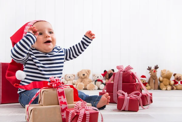 First Christmas: baby unwrapping a present — Stock Photo, Image