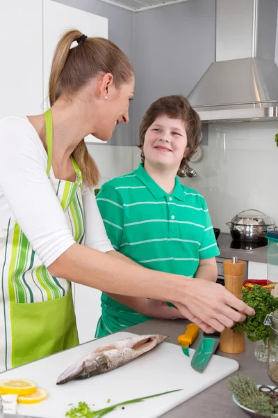 Mãe cozinhar com seu filho na cozinha - vida familiar — Fotografia de Stock
