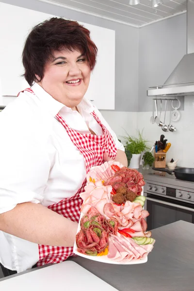Mujer con sobrepeso sosteniendo jamón en rodajas - cocinando en casa — Foto de Stock