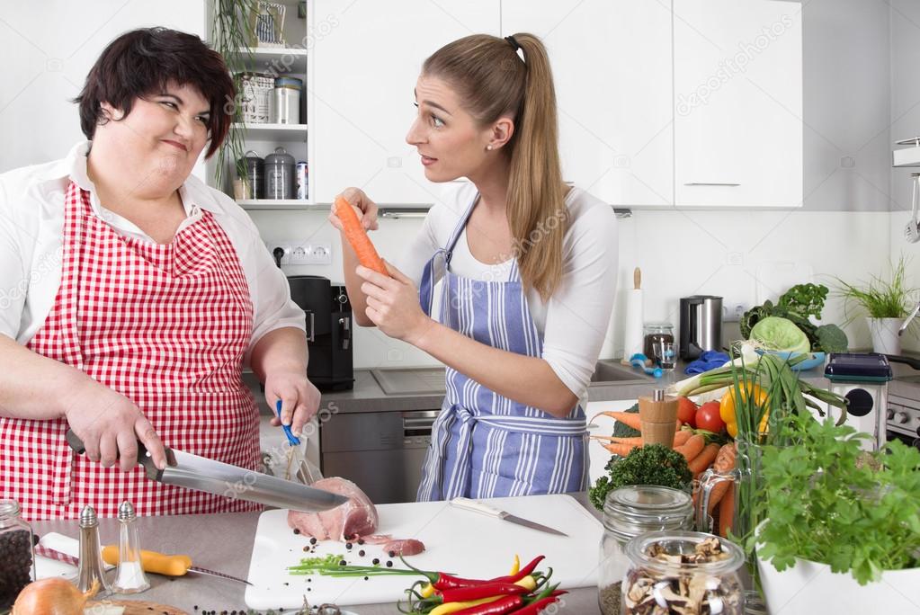Two woman in the kitchen - one slim, one fat - healthy eating -