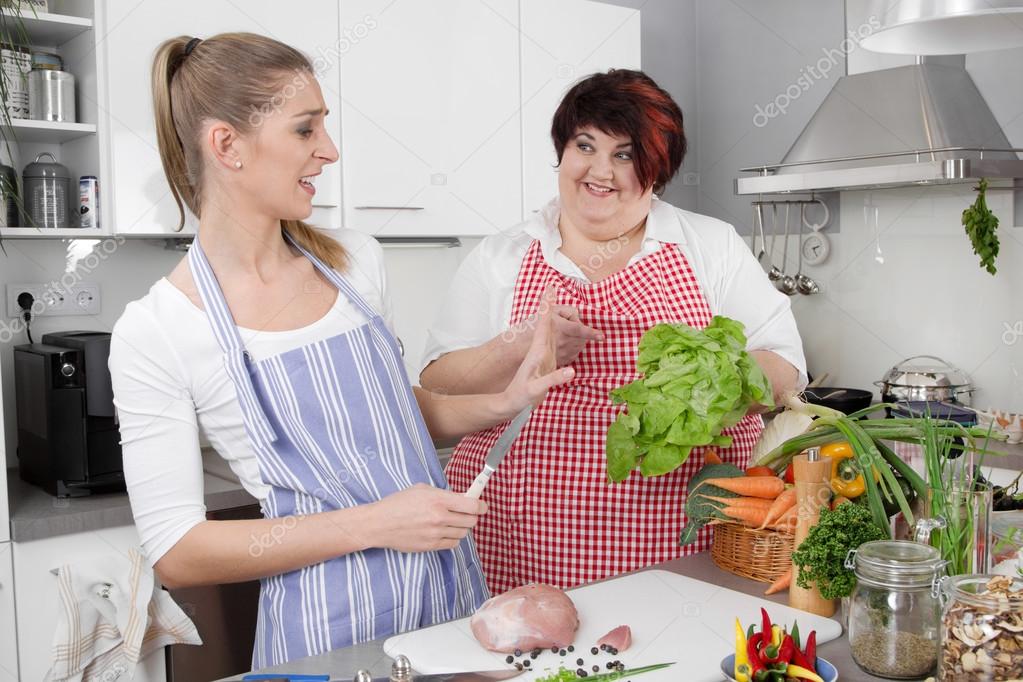 Two woman in the kitchen - one slim, one fat - healthy eating