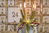 Schäbiger Kalender mit brennenden Kerzen