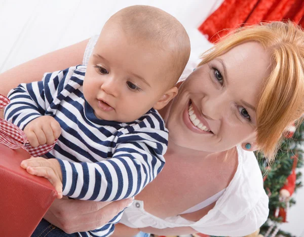 Unconditional love - mother and baby opening a Christmas or birthday