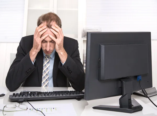 Uomo d'affari oberato di lavoro frustrato e stressato nel suo ufficio con il computer — Foto Stock