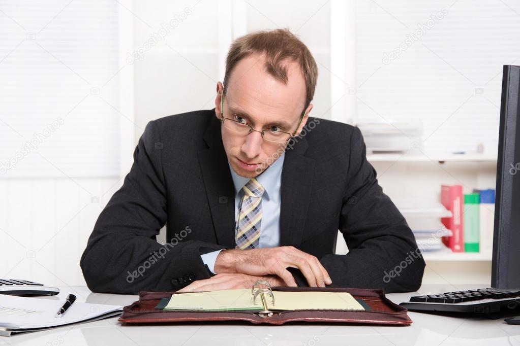 Businessman at desk with problems, stress and overworked sitting