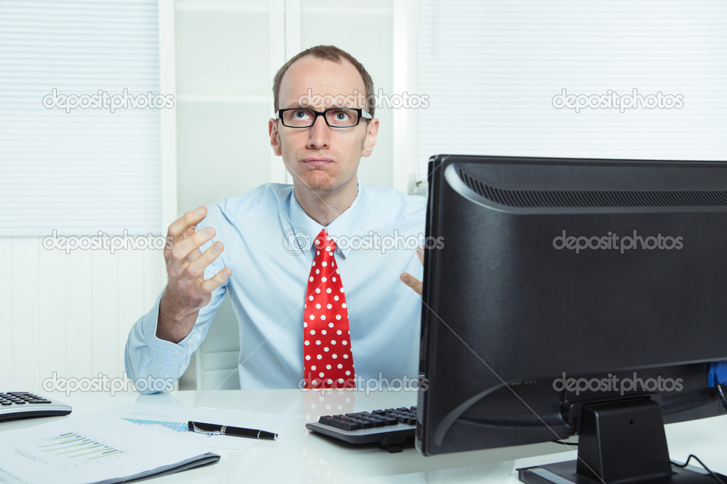 Nervous, annoyed and aggressive businessman sitting at desk in rage