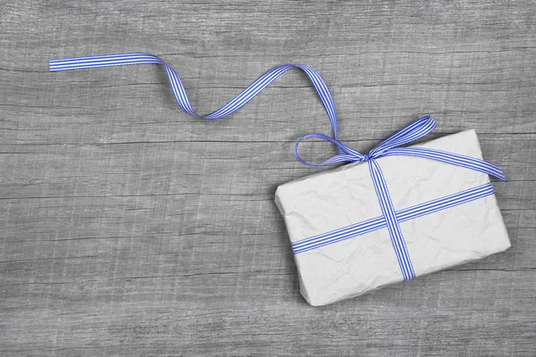 Giftbox with blue striped ribbon — Stock Photo, Image