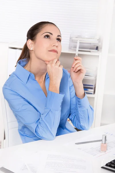 Junge Frau in blauer Bluse sitzt am Schreibtisch und träumt — Stockfoto