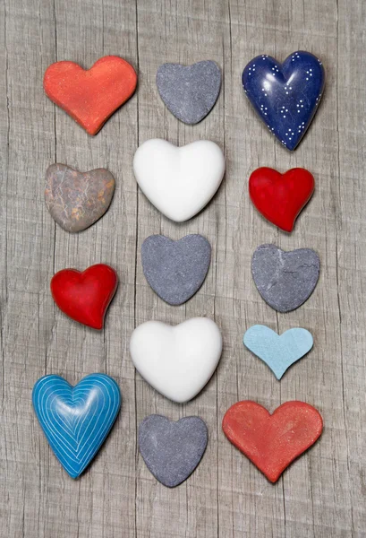 Corazones en diferentes colores sobre fondo de madera . — Foto de Stock