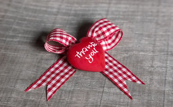 Corazón rojo con "gracias" por una tarjeta de felicitación en la cinta de verificación — Foto de Stock