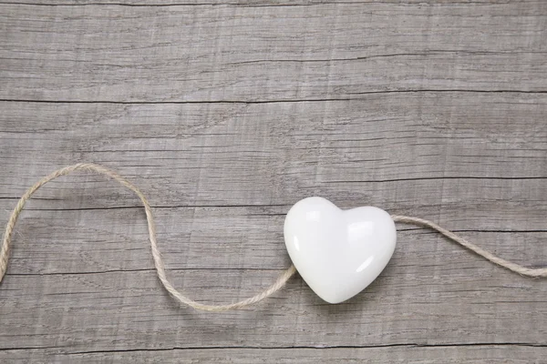 Fondo de madera con un corazón blanco . —  Fotos de Stock