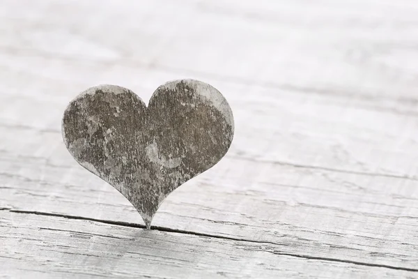 Un corazón de madera sobre un fondo para una tarjeta de felicitación . Fotos de stock