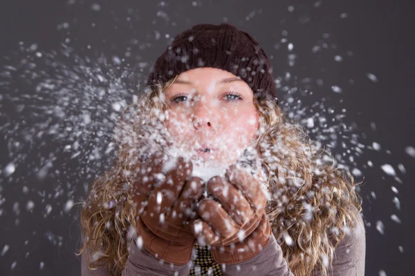 Mujer soplando copos de nieve — Foto de Stock