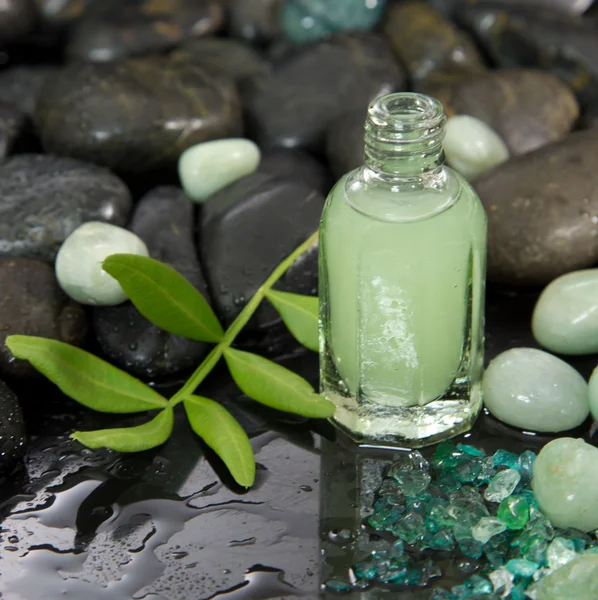 Olio da massaggio verde in una bottiglia di vetro — Foto Stock