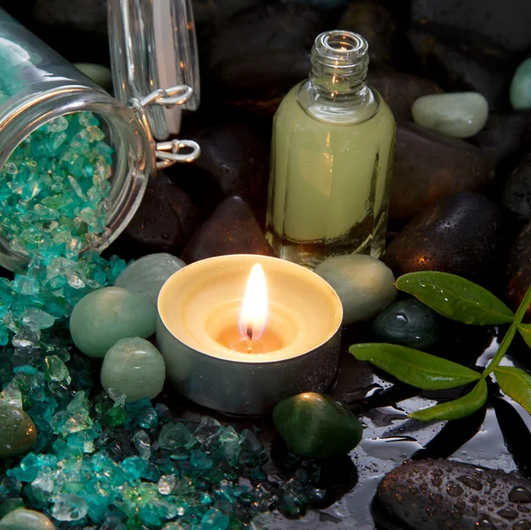 Spa arrangement - natural massage oil with a burning candle — Stock Photo, Image