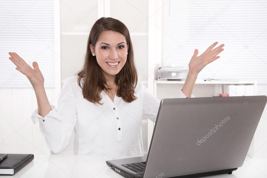 Woman in the office sitting on desk is happy with her work.