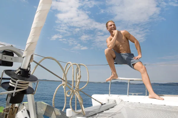 Blond knappe jonge man op zeilboot. — Stockfoto