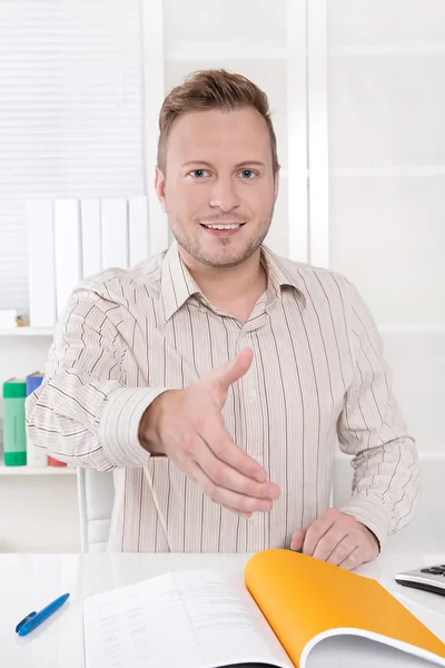 Lächelnder Manager sitzt im Büro - bereit zum Händeschütteln. — Stockfoto