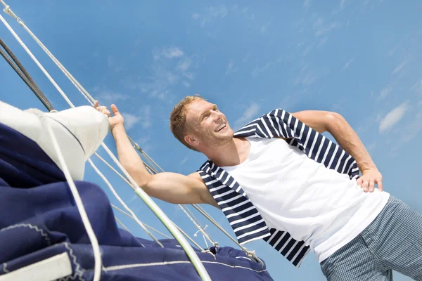 Jovem loiro e bonito no barco à vela . Fotografias De Stock Royalty-Free