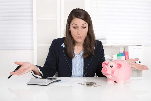 Jonge mooie zakelijke vrouw graaf geld - munten met een piggy verbod Stockfoto