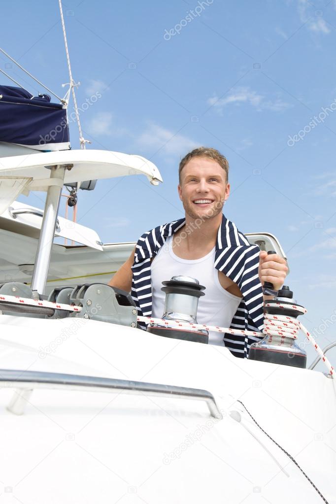 Blond attractive young man on sailing boat.
