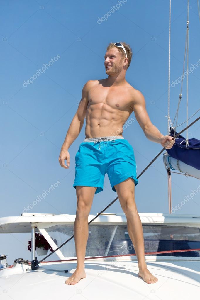 Portrait of sexy young man on sailing boat.