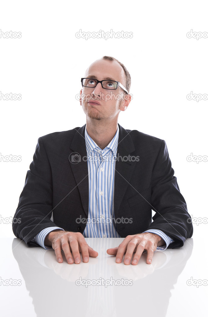 Business man with glasses at desk is thinking about something -