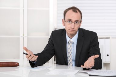 questioningly kel mühendis ya da masa başında oturan uzman.