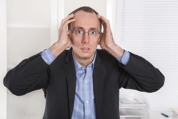 Engenheiro ou especialista questionavelmente careca sentado à mesa . — Fotografia de Stock