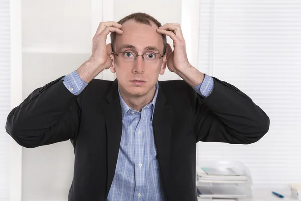 Vragend kale ingenieur of specialist zit aan Bureau. Rechtenvrije Stockfoto's