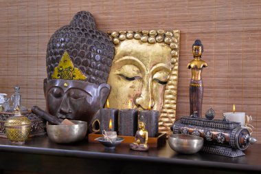 Asya dekorasyon kahverengi ve altın buddha ve mum.