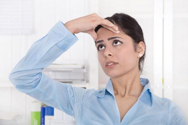 У привлекательной молодой азиатской секретарши мигрень или головная боль.
