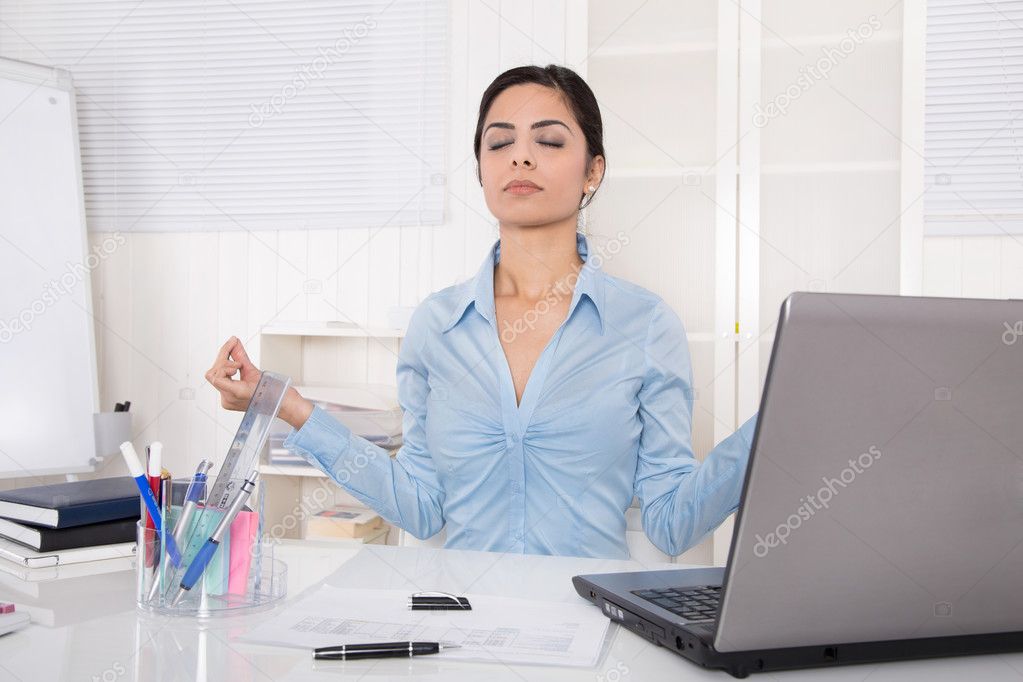 Attractive secretary with closed eyes is doing meditation at off