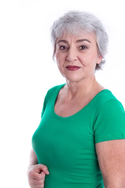 Portret van een senior vrouw geïsoleerd op wit in een groen shirt. — Stockfoto