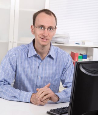 ofiste masa mavi gömlekli gözlüklü broker portresi.