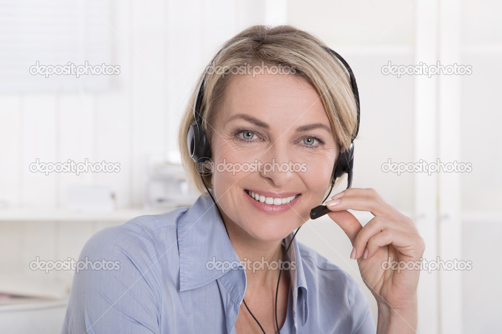 Portrait of smiling blond mature woman working with headphone at