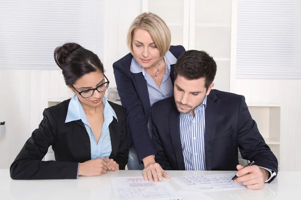 Trabajo en equipo entre tres empresarios en el escritorio de la oficina . — Foto de Stock